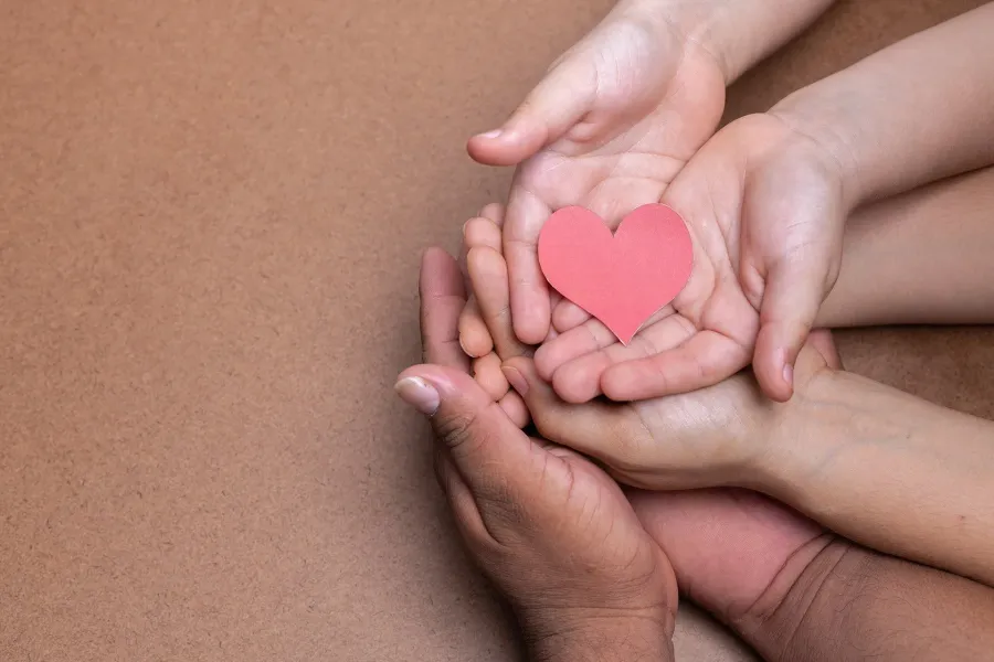 Hands holding a paper heart