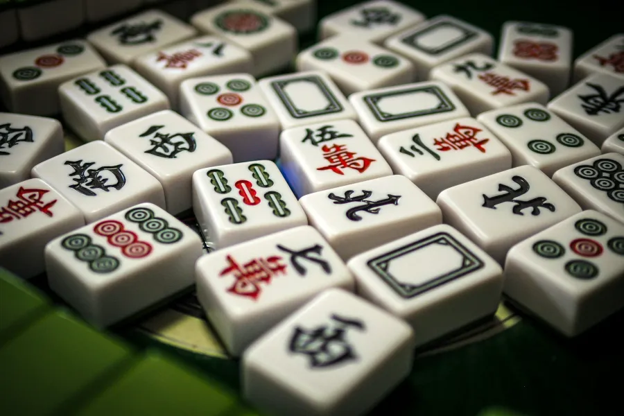 Close-up of mahjong tiles arranged on a green surface